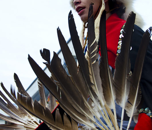 A dancer with the Heinyaa Kwaan group holds fans made of feathers.