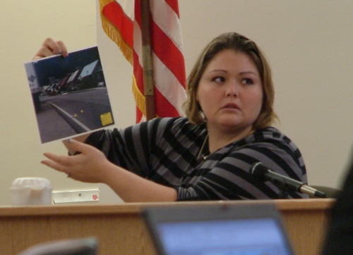 Haley Tokuoka holds up a picture of Hoonah's Front Street where her husband Matthew was shot during John N. Marvin, Jr.'s trial in Oct. 2012. (Photo by Matt Miller/KTOO)  