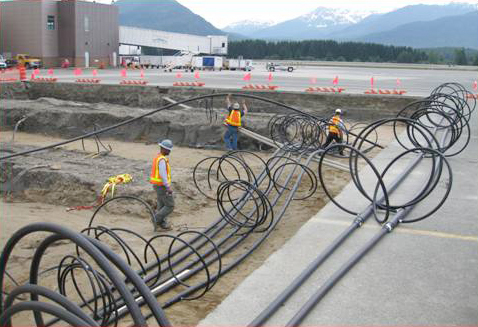 Harri Plumbing and Heating workers install piping in the ground that provides the geothermal ground loop for the airport's heat pump system. There are about 16 miles of piping in the ground. (Photo taken by Airport Construction Assistant, Greg Jerue.)
