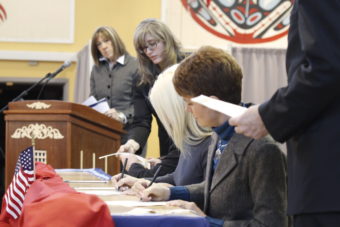 Alaska electors Kathleen Miller and Kristie Babcock sign Alaska’s electoral votes while Election Coordinator Lauri Wilson takes an electoral ballot from elector Christopher Nelson at the 2012 Electoral College vote casting. (Photo by Annie Bartholomew/KTOO)