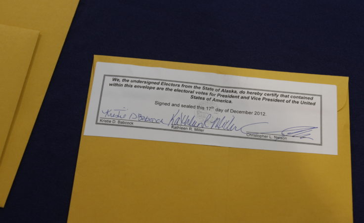A envelope containing electoral ballots signed by Alaska electors Kristie Babcock, Kathleen Miller, and Chris Nelson. (Photo by Annie Bartholomew/KTOO)