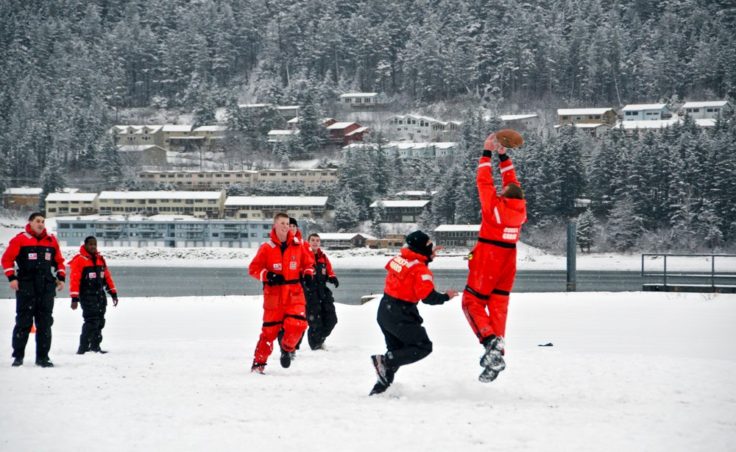 Taking advantage of the perfect snow covered lot, a group from the Coast Guard base take a break for a little football.