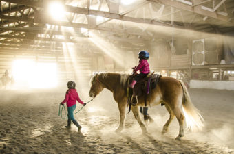 A new 4-H equestrian club in Juneau links riders at Fairweather stables to the Southeast 4-H community.The group hosted their first pony ride in October. Sunlight streams into the dusty barn as Higgins carries another rider around the arena.