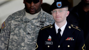 Army Pfc. Bradley Manning (right) is escorted out of a courthouse in Fort Meade, Md., on June 25, 2012. His lawyer announced that Manning, who is accused of leaking classified information to WikiLeaks, had agreed to plead guilty to lesser charges. Patrick Semansky/AP