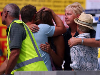 People grieve outside New Zealand's Muriwai Surf Lifesaving Club after the fatal shark attack at Muriwai Beach on Wednesday. Phil Walter/Getty Images