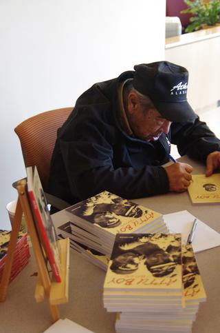 Attu survivor and author Nick Golodoff signs copies of Attu Boy. (Photo by Stephanie Joyce/KUCB)