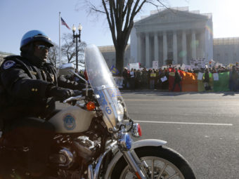 A Washington D.C. motorcycle police officer kept watch on demonstrators outside the Supreme Court Tuesday morning. Jonathan Ernst /Reuters /Landov