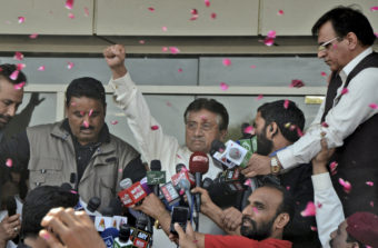 Former Pakistani President Pervez Musharraf greets supporters upon his arrival at Karachi airport in Pakistan on Sunday. S.I. Ali/AP