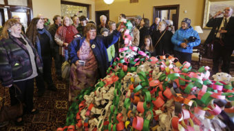Outside the office of Utah Gov. Herbert Friday, Betsy Ogden lays paper chains on a pile symbolizing uninsured state residents who would be covered by a Medicaid expansion. Rick Bowmer/AP