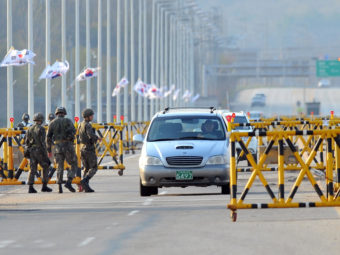 South Korean soldiers stand beside barricades as cars drive on the road leading to North Korea's Kaesong industrial complex on Friday. Jung Yeon-je/AFP/Getty Images