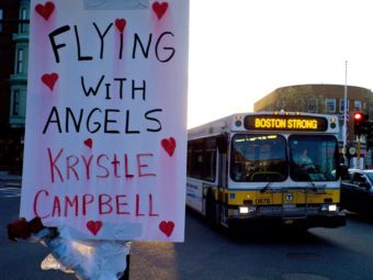 A sign reading "Flying With Angels Krystle Campbell," is seen Monday as a passing MBTA bus with "Boston Strong" displayed on its message board drives through Medford, Mass. A funeral service for Campbell, one of the three people killed in the marathon bombings, was to be held later in the day. C.J. Gunther /EPA /LANDOV