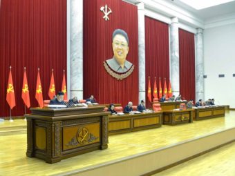 North Korea's KCNA news agency released this photo Monday, saying it shows leader Kim Jong Un (at left) speaking during a plenary meeting of the Central Committee of the DPRK in Pyongyang. Hanging above is the image of his father, former leader Kim Jong Il, who died in 2011. Xinhua /Landov