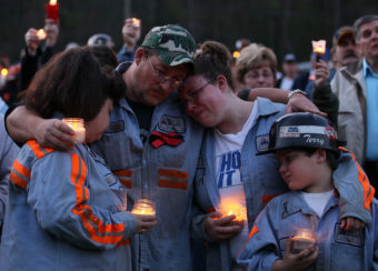 In this 2010 photo, coal miner Terry Cooper, left, embraces his wife Michelle, daughter Tera and son Justin, during a vigil to honor the coal miners that were killed in Montocal, West Virginia. Mark Wilson/Getty Images