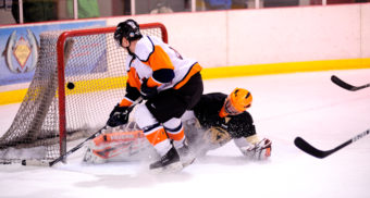 Alec Venechuk lifts a backhand shot past a sprawling Jerry Nankervis in goal during a Tier A playoff contest.
