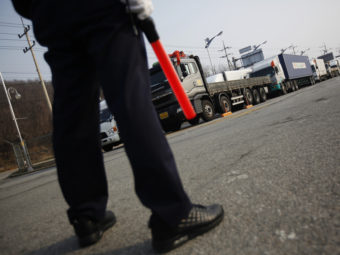 On Thursday, a South Korean security guard kept watch as South Korean trucks waited to enter the Kaesong industrial complex in North Korea. For the second day, the North blocked the trucks and workers from the South from entering its territory. Kim Hong-ji /Reuters /Landov