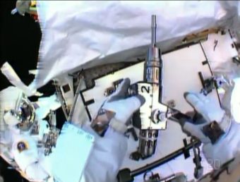 In this image made from video provided by NASA, astronaut Christopher Cassidy, foreground, holds a power wrench as he stows away a coolant pump on the International Space Station on Saturday. Thomas Marshburn is at left. AP