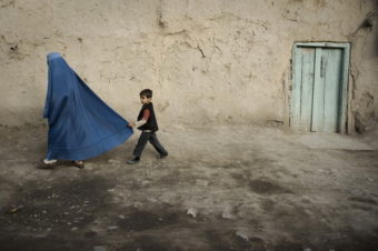 A boy holds the burqa of his mother as they walk down a street in the old city of Kabul on November 1, 2009. Nicolas Asfouri/AFP/Getty Images