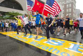 Runners holding American flags and a Chinese flag cross the finish line after completing the final mile of the Boston Marathon course during "#onerun" in Boston, Massachusetts on Saturday. Dominick Reuter /Reuters /Landov