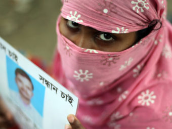 A Bangladeshi family member holds up the portrait of her missing relative, believed to be trapped in the rubble of the collapsed Rana Plaza. AFP/Getty Images