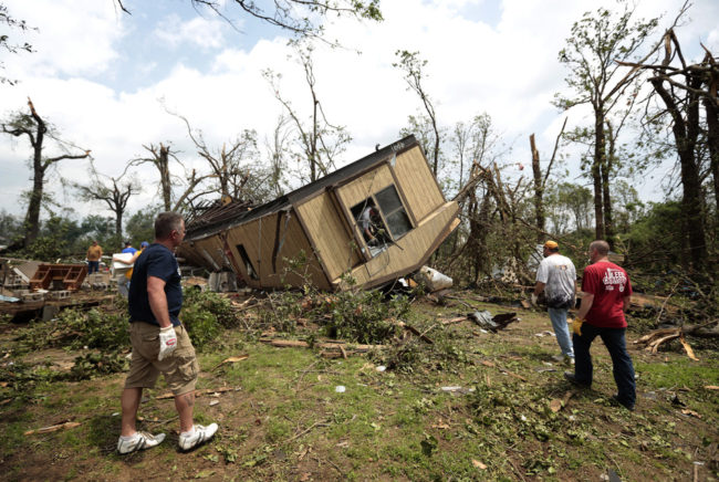 Volunteers help clean out Jean McAdams' mobile home after it was overturned by a tornado today near Shawnee, Oklahoma. Brett Deering/Getty Images