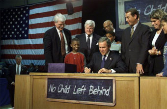 Visiting Hamilton High School in Hamilton, Ohio, Jan. 8, 2002, President George W. Bush signs into law the No Child Left Behind Act.