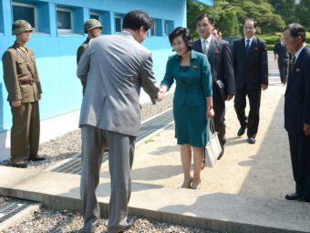 South Korea's delegate (left) shakes hands with North Korea's head of working-level delegation Kim Song-Hye as she crosses the military demarcation line for the meeting at border village of Panmunjom. Handout/Getty Images