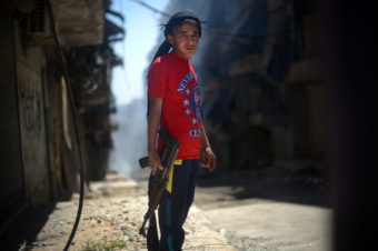 A Syrian boy holds an AK-47 assault rifle in the majority-Kurdish Sheikh Maqsud district of the northern Syrian city of Aleppo in April. Dimitar Dilkoff /AFP/Getty Images