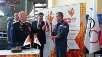 Former cosmonaut Alexey Leonov, left, the first man to perform a spacewalk, passed an Olympic torch to Mikhail Tyurin, who will lead the mission to the International Space Station in November. DChernyshenko/
