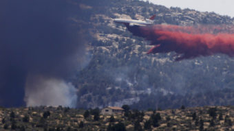 An aerial tanker drops fire retardant on a wildfire threatening homes near Yarnell, Ariz., on July 1. An elite crew of firefighters was overtaken by the out-of-control blaze on June 30, killing 19 members as they tried to protect themselves from the flames under fire-resistant shields. Chris Carlson/AP
