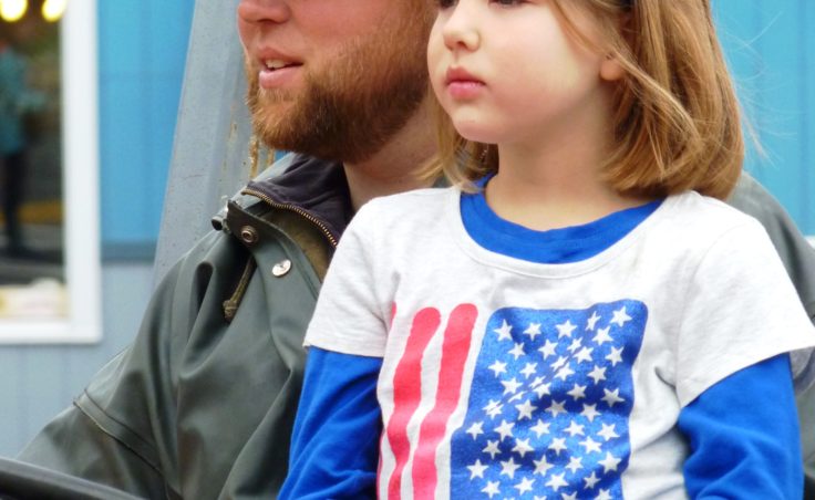 Patriotic young lady with her miner father in the Juneau parade.