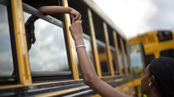 Laterrica Luther, right, holds the hand of her 6-year-old nephew Jaden Culpepper, as students from the Ronald E. McNair Discovery Learning Academy arrive on school buses to waiting loved ones in a Walmart parking lot Tuesday in Decatur, Ga. A gunman had entered the students' school earlier in the day. No one was hurt. David Goldman/AP