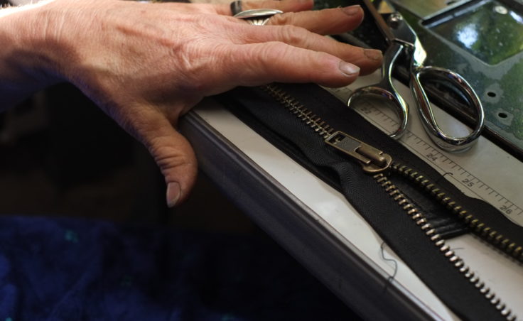 A picture of a hand working on a zipper