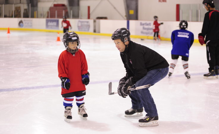 JDIA coach Jason Kolhase greets a newcomer to the ice at the youth hockey association’s Learn to Play event Saturday.