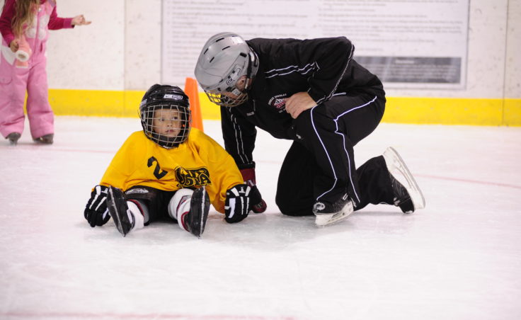 JDIA coach Jim deLaBruere helps Trevor Stephens during JDIA’s Learn to Play event Saturday at Treadwell Ice Arena.