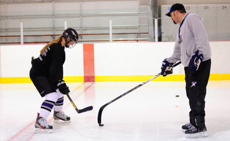 Bryan Smith works with Emma Kaelke during a shooting drill drawn up by Smith at the Rocky Mountain Hockey School.