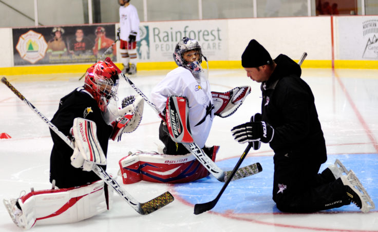 Chad Macleod (right) works with goalies Kyle Robinson (black jersey) and Wolf Dostal (white jersey) throughout the week at the Rocky Mountain Hockey School.