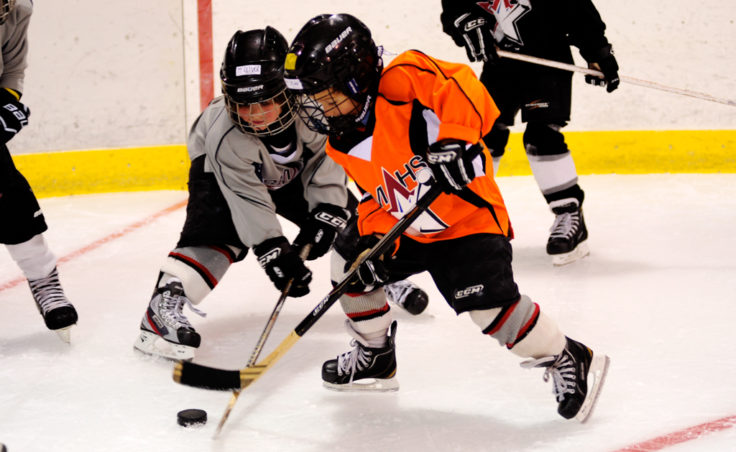 From left, Oliver Stopher and Dylan Sowa battle for a puck while working on a drill at the Rocky Mountain Hockey School.