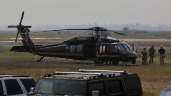 Authorities wait near a blackhawk helicopter at the Cascade Airport in Cascade, Idaho, on Saturday as they comb Idaho's Frank Church River of No Return Wilderness. Robby Milo/Associated Press