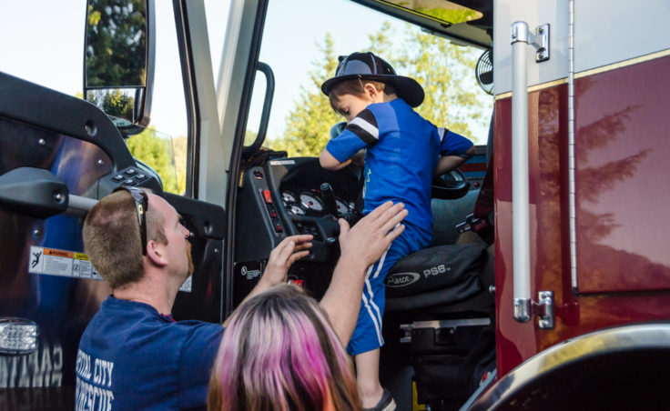 Firefighter Craig Brown helps Tristan Winchell, 4, from the front seat of Engine 31.