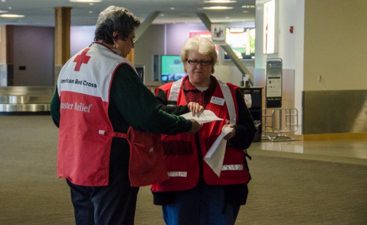 Red Cross volunteers wait inside the airport terminal to direct arriving family members to the waiting area.