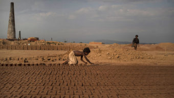 Near Islamabad, Pakistan, 6-year-old Jabro Mounir was arranging bricks this summer — part of his daily work at a brick-making facility. He earns a little less than $2 per day. Muhammed Muheisen/AP