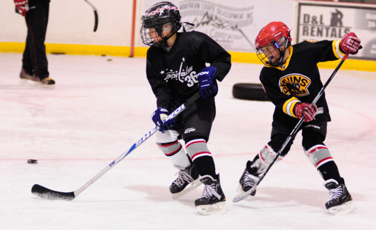 Finn Shibler evades Gage Cooney during a puck possession drill at Steve MacSwain’s two-day hockey camp held at Treadwell Ice Arena.
