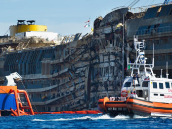 A Coast Guard patrols in front of the severely damaged right side of the Costa Concordia cruise ship after it was righted last week. Marco Secchi/Getty Images