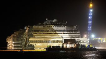 The Costa Concordia is seen after it was lifted upright on the Tuscan Island of Giglio, Italy, early Tuesday morning. Officials declared the results of the 19-hour operation "perfect." Andrew Medichini/AP