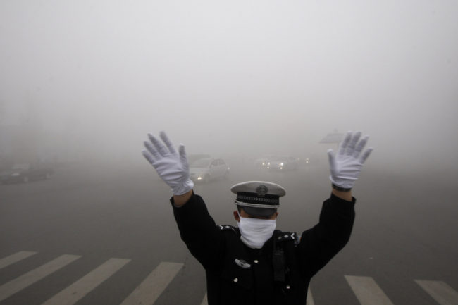 A policeman gestures as he works on a street in heavy smog in Harbin, northeast China's Heilongjiang province, on Monday. AFP/AFP/Getty Images