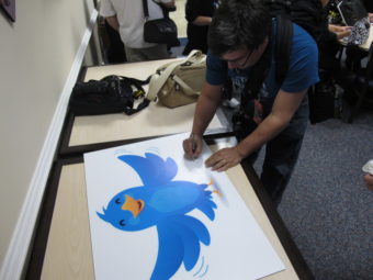 In this Nov. 8, 2011, photo, NASA fan David Parmet signs his name on a Twitter logo during a tweetup event for about 50 of NASA's Twitter followers at the Langley Research Center in Hampton, Va. Brock Vergakis/AP