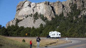 Tourists stop on the roadside near Mount Rushmore, after their visit was canceled due to the government shutdown. South Dakota and other states have reached an agreement to fund operations to reopen the parks. Scott Olson/Getty Images