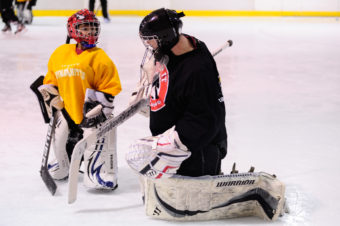 Neal Chapman, right, pulls double duty as a student and teacher as a group of goalies work on their game during a JDIA skills development camp.