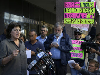 Roxanne Sanchez, left, president of Service Employees International Union Local 1021, left, speaks during a news conference on Thursday in Oakland, Calif. Ben Margot/AP