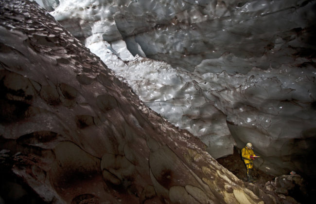 Mapping another world: An explorer writes down survey data in a glacier cave on Mount Hood. Brent McGregor